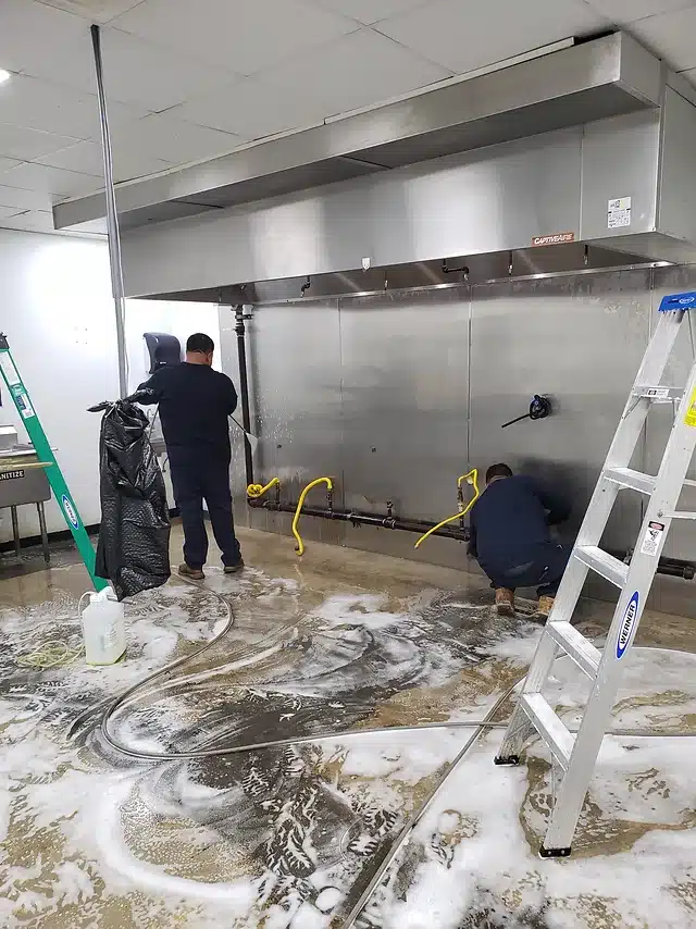 Technicien Mister Hotte effectuant le dégraissage hotte professionnelle de restaurant à Paris